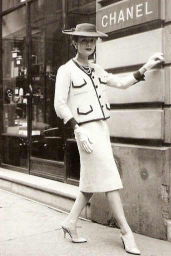 Modelo posa em frente à Maison Chanel, usando o famoso tailleur